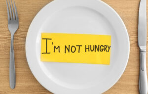 White plate with words I'm not hungry on wooden background